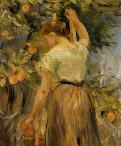 Joven mujer recogiendo naranjas